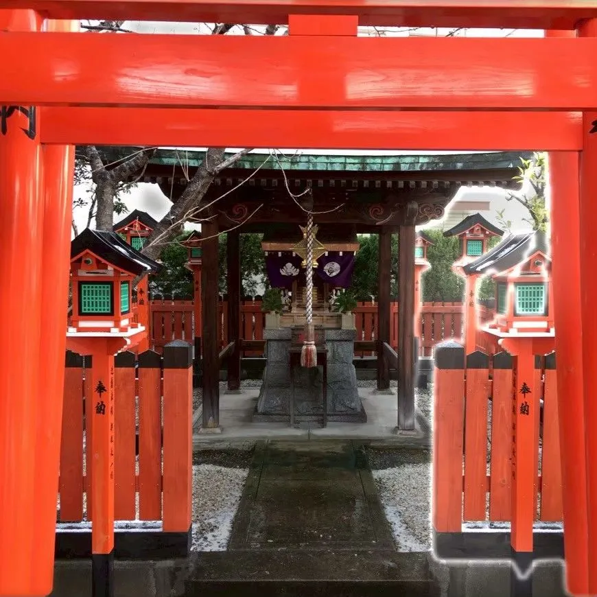 朱塗りの鳥居越しに見える社殿と灯籠の全景